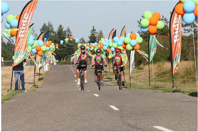 Feather flags lining the road, encouraging bike riders in a company fundraising event.