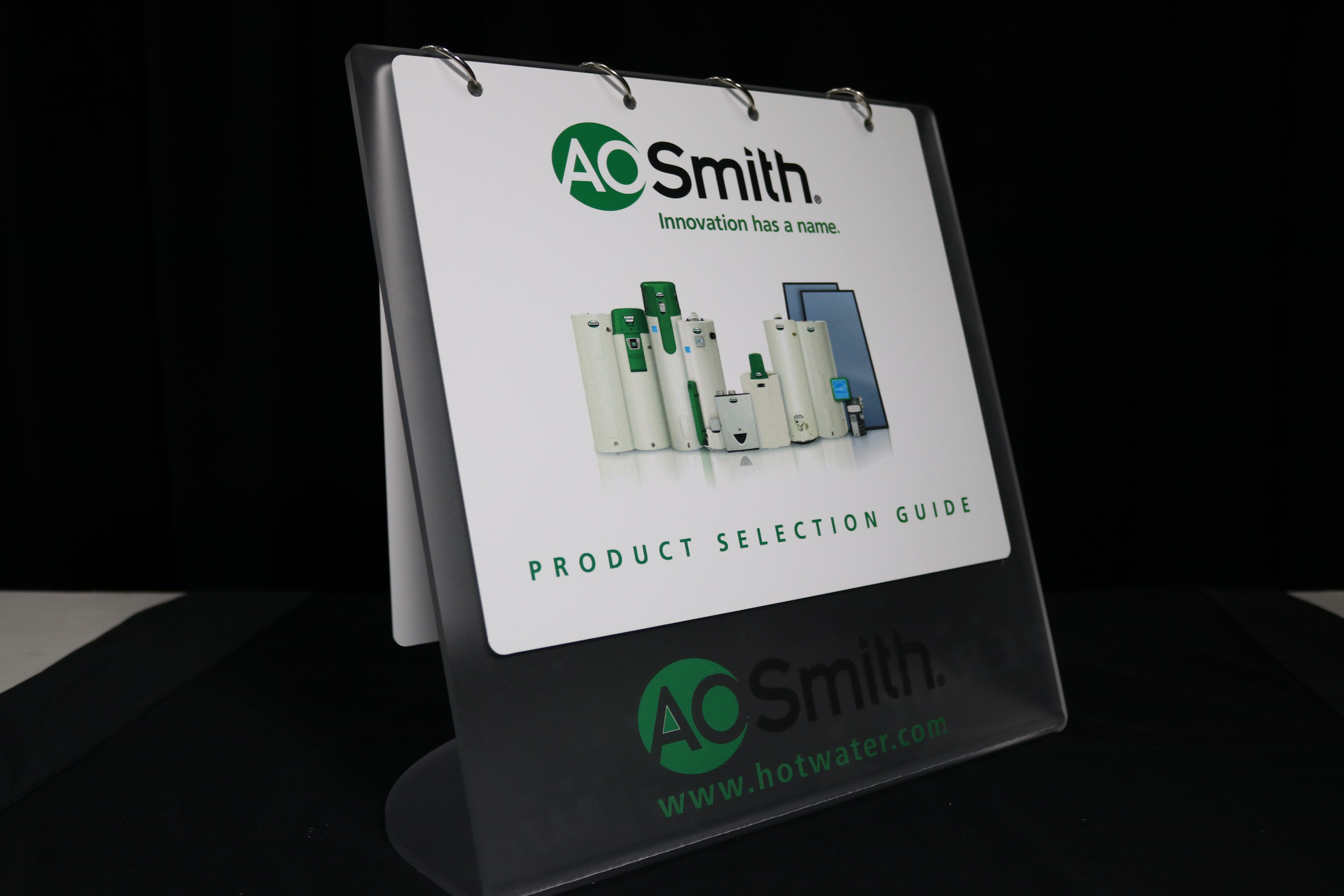 Tabletop flip-style product display with pages printed on styrene on a self standing frosted acrylic board.