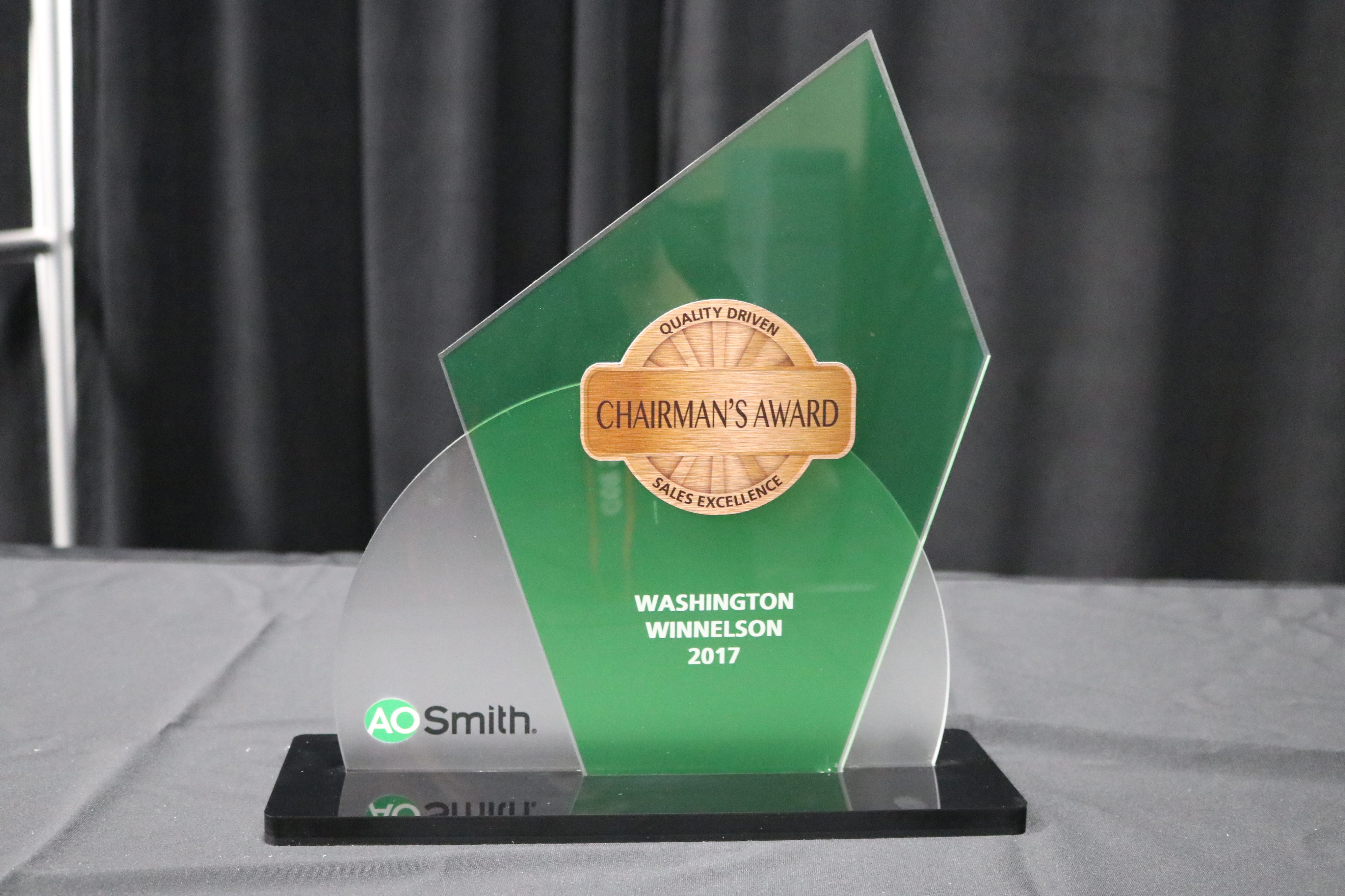 Acrylic award with unique shapes cut out, frosted finish, and green translucent print.