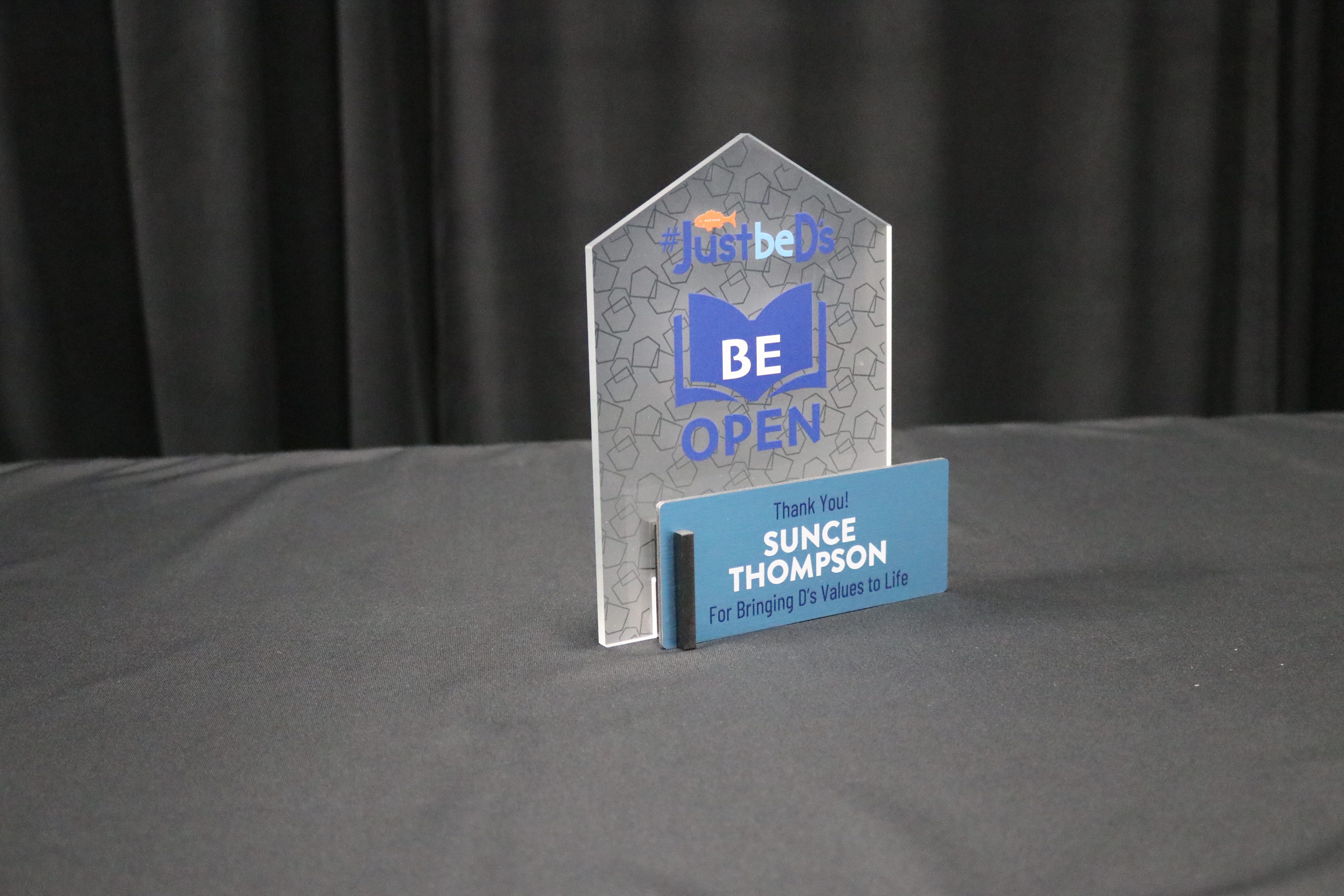 Tabletop core values award with printed frosted acrylic back and printed blue on brushed metal front.