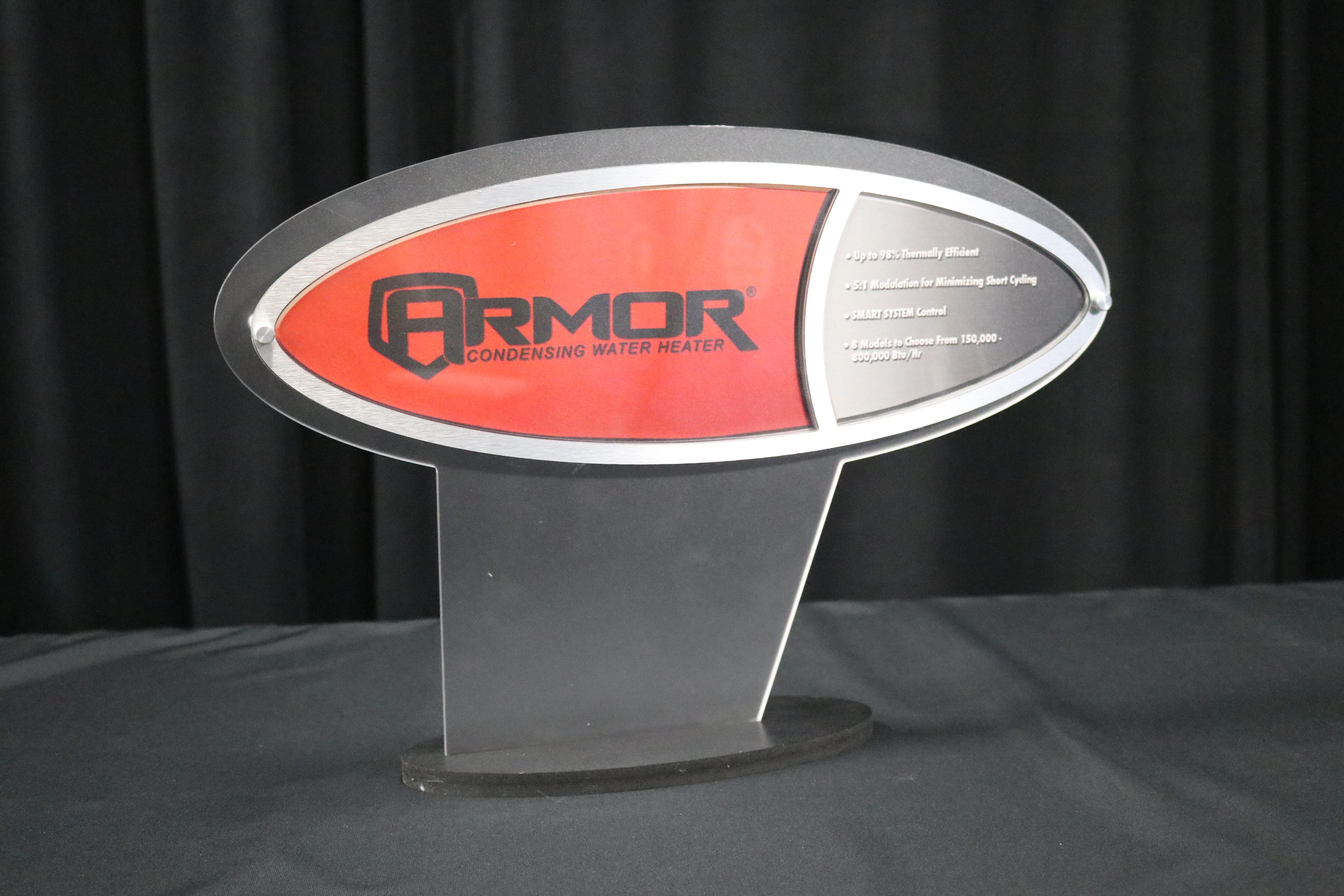 Frosted acrylic tabletop display with a logo mounted to face with stand-offs and brushed silver dibond accents.