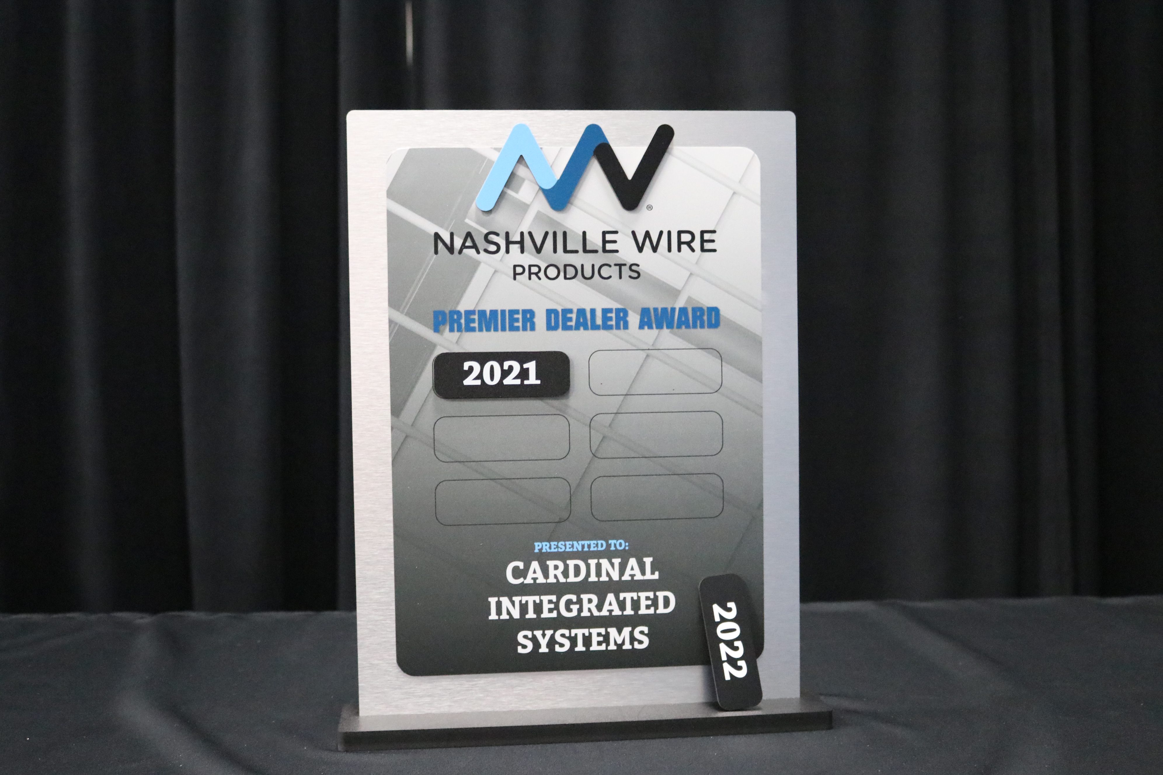 Updateable tabletop award with a steel printed face mounted to brushed aluminum and magnetic years.