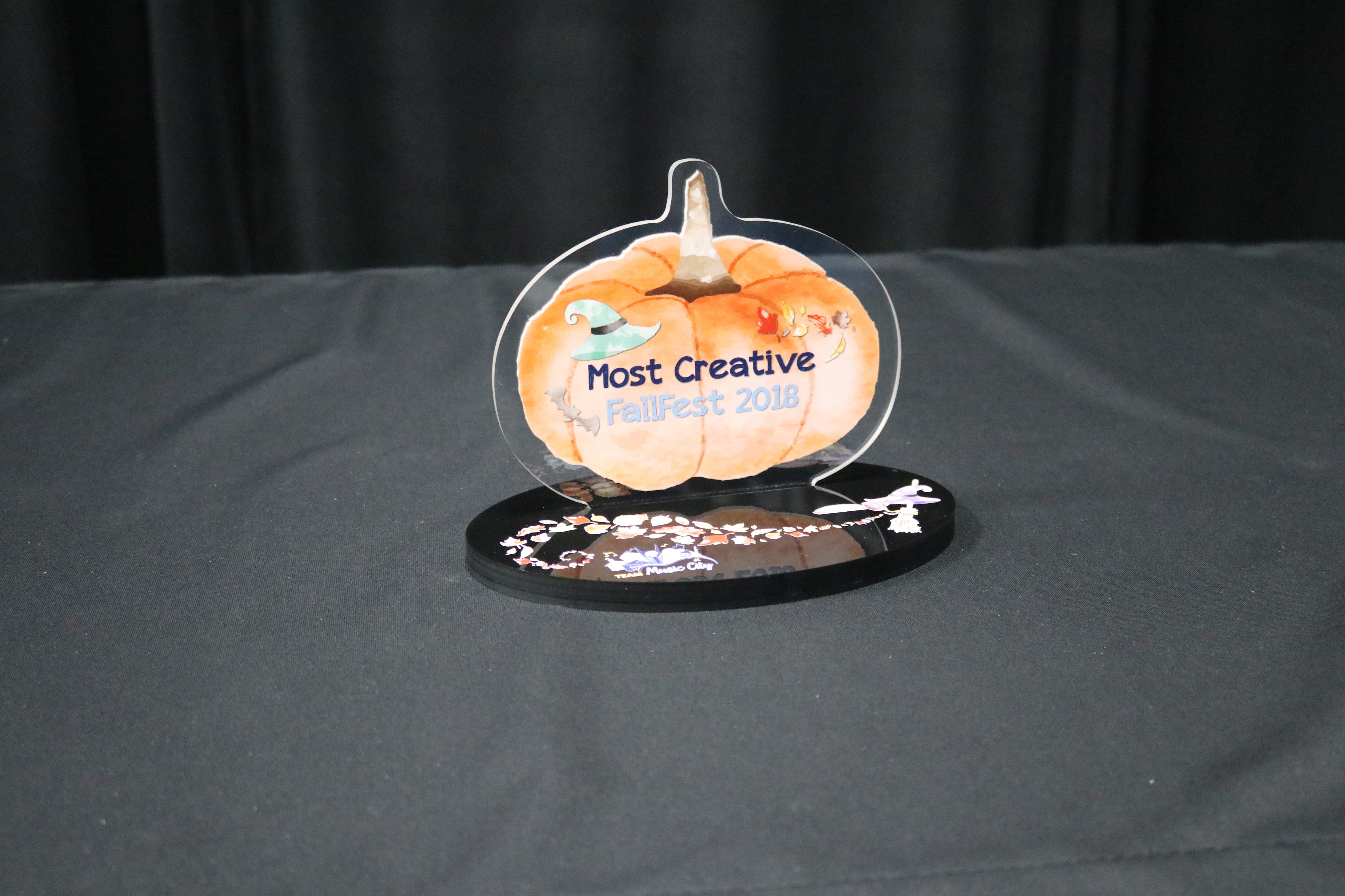 Acrylic award with printed pumpkin on clear acrylic inserted into black base with design printed on.
