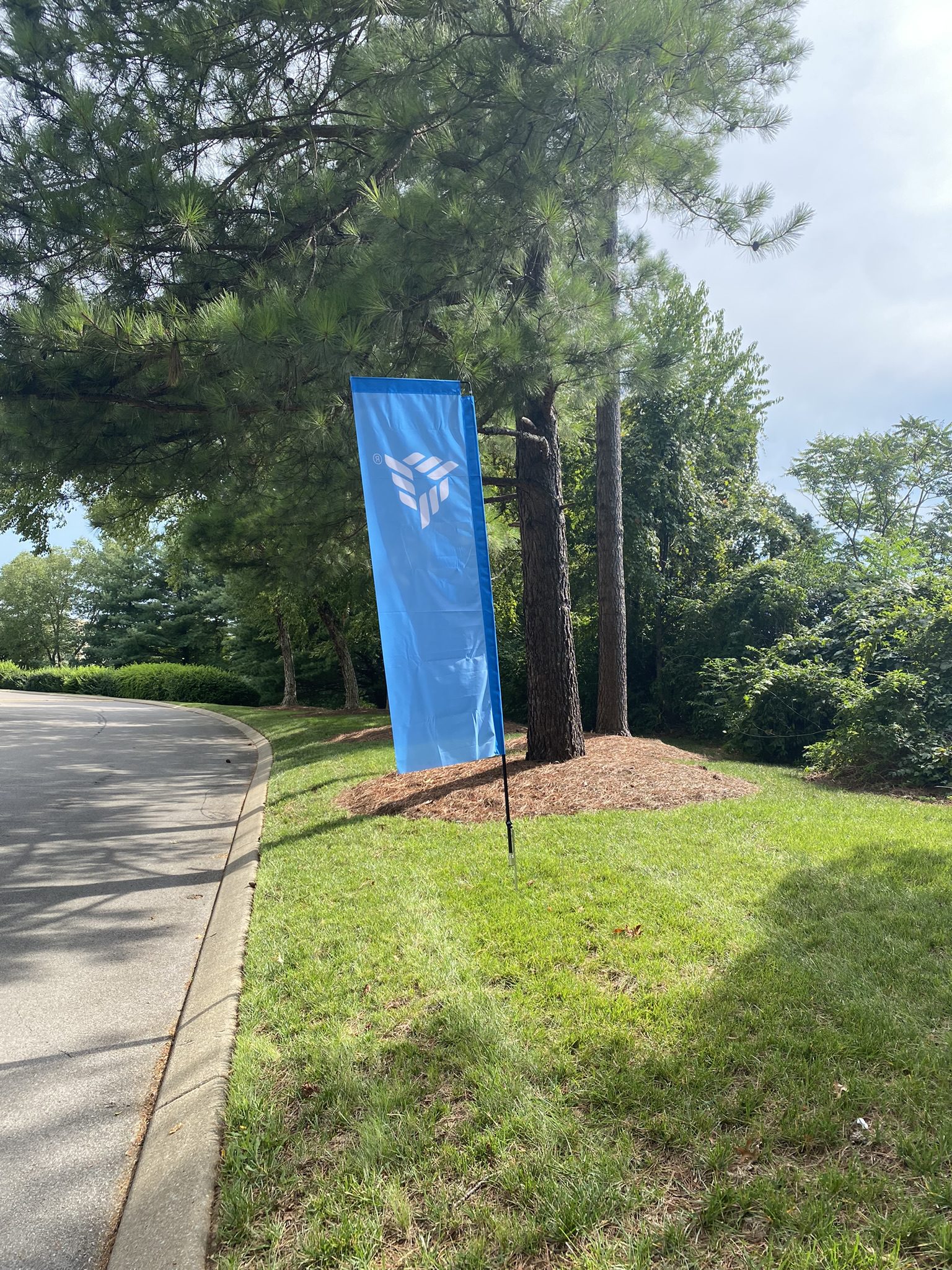 Straight feather flag with company logo and ground stake.