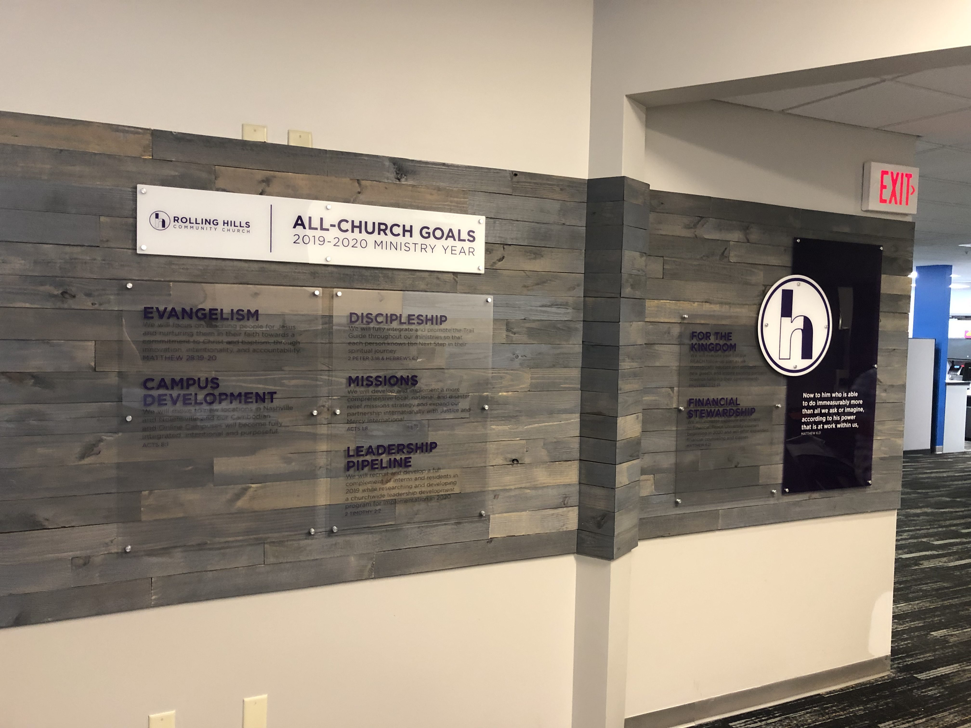 Printed acrylic signage mounted to a wood wall with stand-offs.