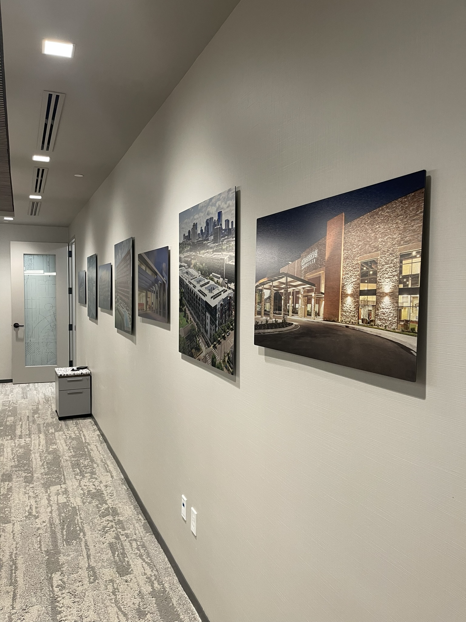 brushed silver metal photo prints for office wall decor Brushed silver metal photo prints of project highlights on office wall