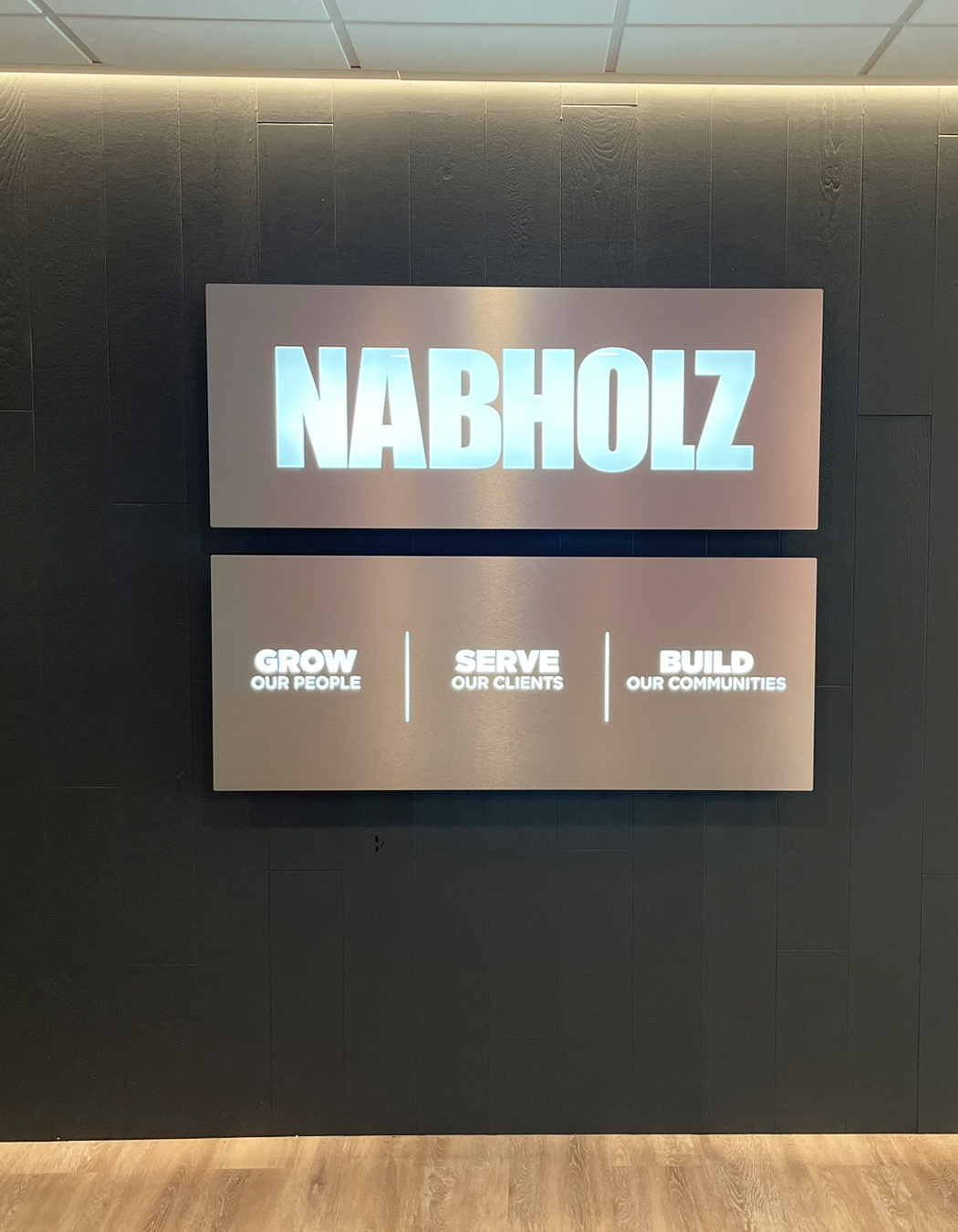 Custom LED Logo sign with core values Illuminated 3D logo wall sign with LEDs displayed in modern corporate office lobby