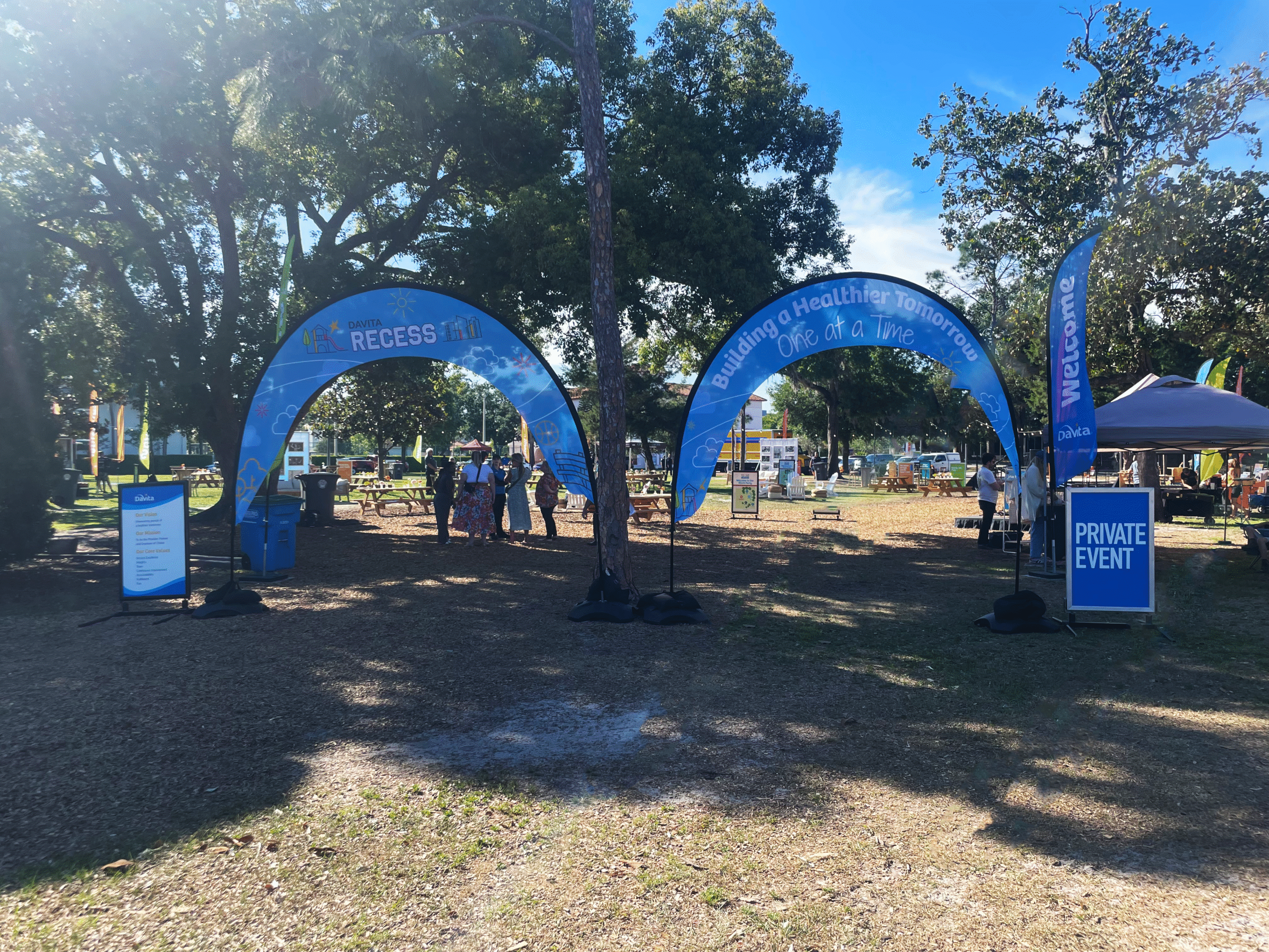 Outdoor event signage with custom printed graphics on flags, arches, and wayfinding signs